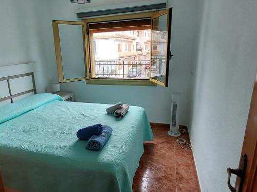 a bedroom with two towels on a bed with a window at Apartamento Paraíso en Santa Pola in Santa Pola