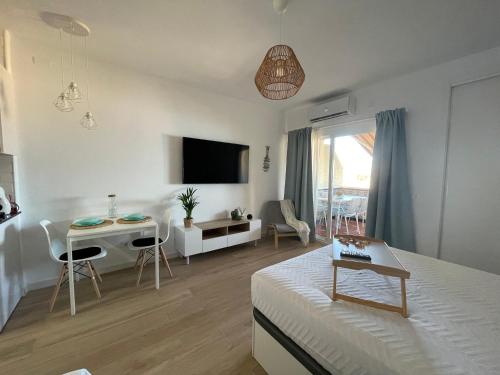 ein Wohnzimmer mit einem Bett, einem Tisch und Stühlen in der Unterkunft Benalbeach Smart Suite in Benalmádena