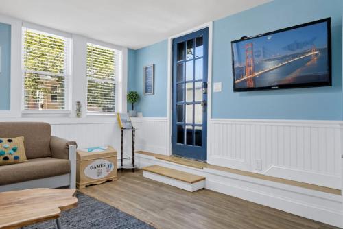 a living room with a tv on a blue wall at Gammys Beach Bungalow in Ventnor City