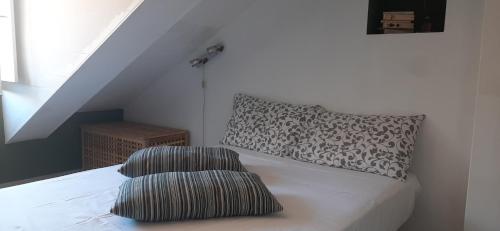 een slaapkamer met een bed met 2 kussens erop bij Stylish Loft Gioia in Turijn