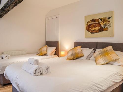 a bedroom with three beds with towels on them at Mount Farm - The Stable in Harker