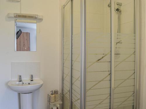 a bathroom with a sink and a glass shower at Mount Farm - The Stable in Harker