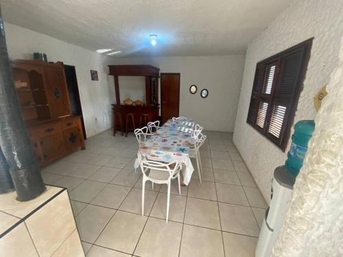 a dining room with a table and white chairs at Casa de Praia no Porto das Dunas in Aquiraz
