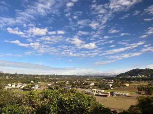 a view of a town under a blue sky with clouds at Lemuju B&B Hotel in Daxi