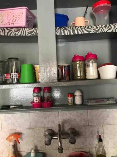 a shelf above a kitchen sink with dishes on it at Studio apartment California 15 minutos de Ezeiza in Monte Grande