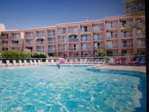 une personne dans l'eau devant un hôtel dans l'établissement studio calme et paisible avec piscine et parking privé, à Balaruc-les-Bains