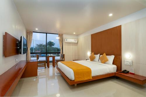 una camera d'albergo con letto, tavolo e sedie di Pai Resort a Belgaum