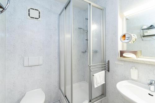 a bathroom with a shower and a toilet and a sink at Gasthof und Pension Frankenthal - garni in Gera