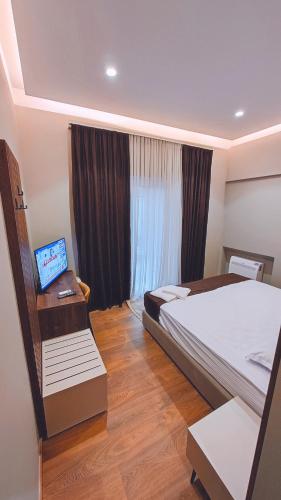 1 dormitorio con 1 cama y escritorio con ordenador portátil en Vila Casablanca - Boutique Hotel & Restaurant, en Shkodër