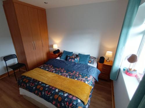 um quarto com uma cama com uma colcha colorida em Happy guest em Dublin