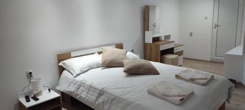 1 dormitorio con 1 cama grande con sábanas y almohadas blancas en Arts Guest House -Beautiful villa for 6 persons, en Veliko Tŭrnovo
