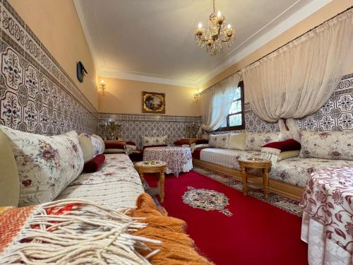 a living room with couches and a chandelier at Villa de l'atlas 