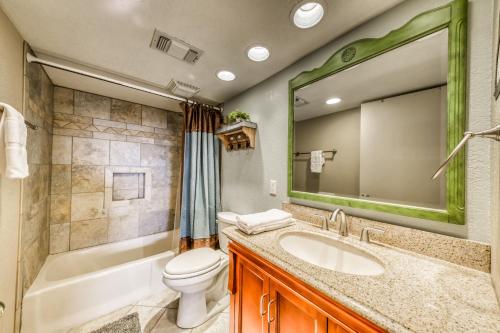 a bathroom with a sink and a toilet and a mirror at Living the Dream, 3 Bedrooms, Hot Tub, Fireplace, Sleeps 6 in Ruidoso