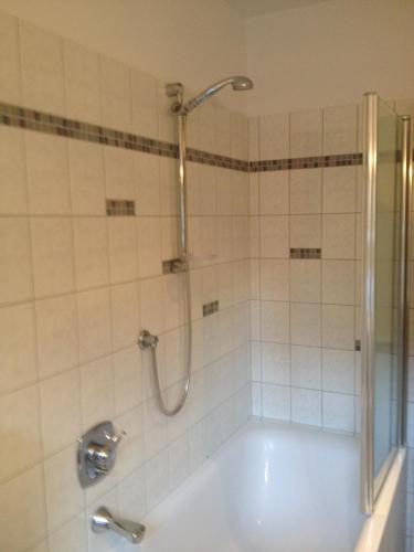 a bathroom with a shower and a bath tub with a sink at Villa Rauter Mayrhofen in Mayrhofen