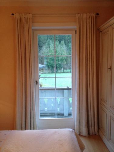 a bedroom with a window and a bed with curtains at Villa Rauter Mayrhofen in Mayrhofen
