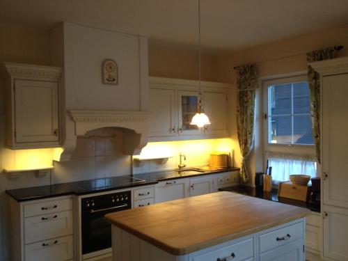 a kitchen with white cabinets and a wooden counter top at Villa Rauter Mayrhofen in Mayrhofen