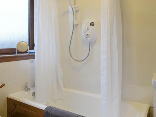 ein Bad mit einer Dusche mit einem weißen Duschvorhang in der Unterkunft Toab - Uk5662 in Aberdeen