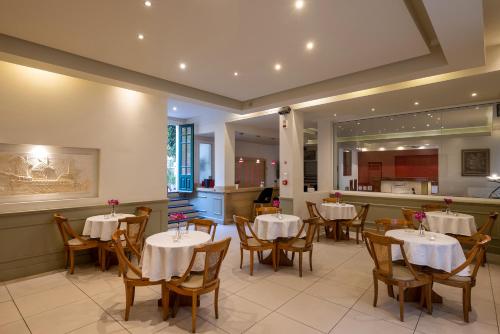a restaurant with tables and chairs and a kitchen at Hotel Palladion in Ermoupoli