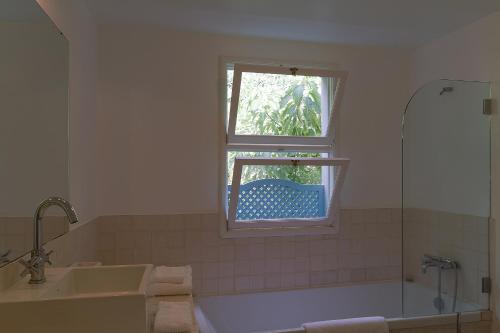 a bathroom with a tub and a sink and a window at Casa da Madalena do Mar in Madalena do Mar