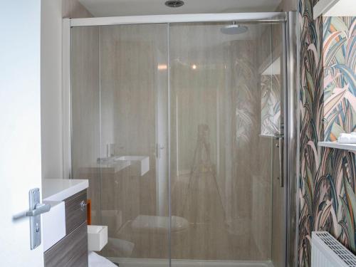 a shower with a glass door in a bathroom at Bogrie Country Cottage in Canonbie
