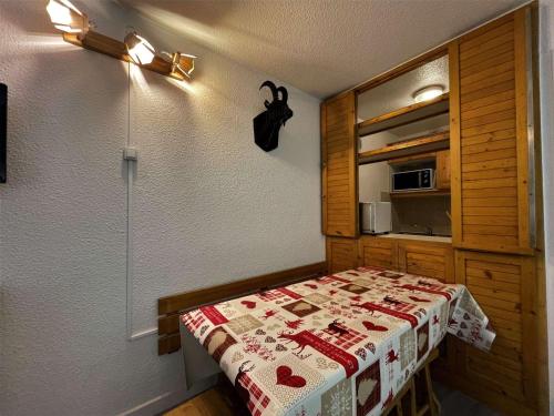 - une chambre avec un lit et un four micro-ondes dans l'établissement Appartement cosy avec balcon, 2 pièces, 5 pers, proche pistes et commerces - FR-1-452-249, aux Menuires