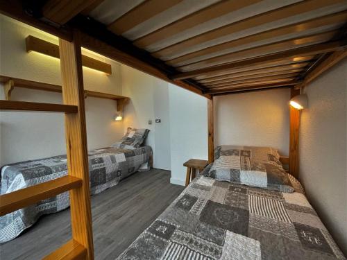 deux lits dans une chambre avec plafonds en bois dans l'établissement Appartement cosy avec balcon, 2 pièces, 5 pers, proche pistes et commerces - FR-1-452-249, aux Menuires