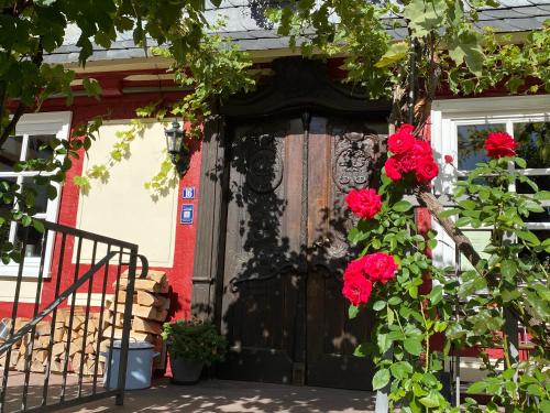 a black door with red flowers on it at Hotel Weber in Amöneburg