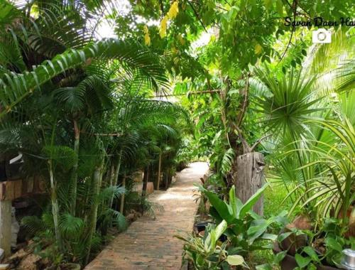 a path in a jungle with trees and plants at Sala Thongyon - Guest House in Savannakhet