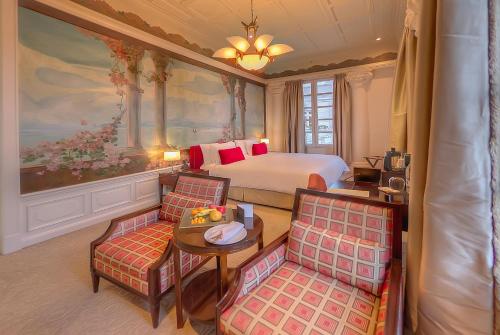 a hotel room with a bed and a table and chairs at Hotel Casa Gangotena in Quito