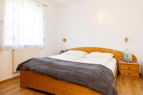 um quarto com uma cama de madeira e uma janela em Appartements Walzl em Maria Lankowitz