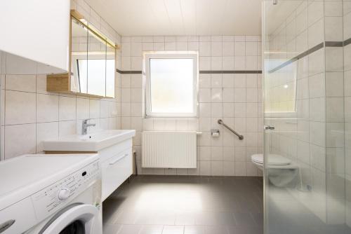 a white bathroom with a sink and a toilet at Appartmenthaus Köflach in Köflach
