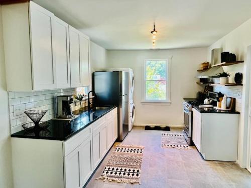 una cucina con armadietti bianchi e frigorifero di Modern Cottage The Whitney by The Bay a Villas