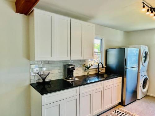 a kitchen with white cabinets and a refrigerator at Modern Cottage The Whitney by The Bay in Villas
