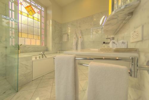 a white bathroom with a sink and a tub at Hotel Casa Gangotena in Quito