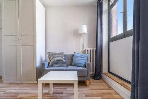 - un salon avec un canapé bleu et une table dans l'établissement Nice and bright studio close to Paris - Pantin - Welkeys, à Pantin