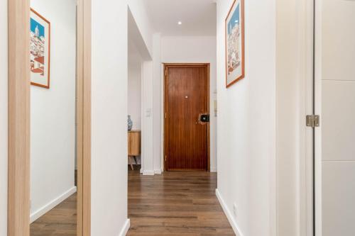 a hallway with white walls and a wooden door at Lovely 2 Bedroom Apartment in Caparica in Almada
