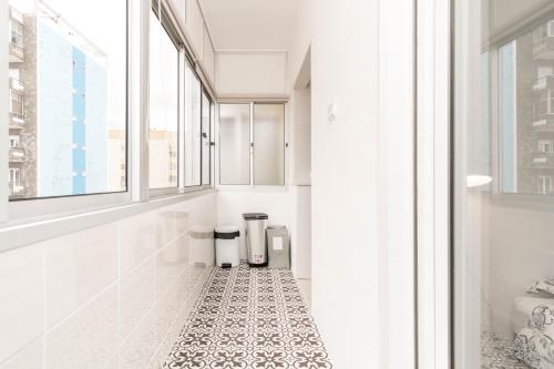 a white bathroom with a black and white tiled floor at Lovely 2 Bedroom Apartment in Caparica in Almada