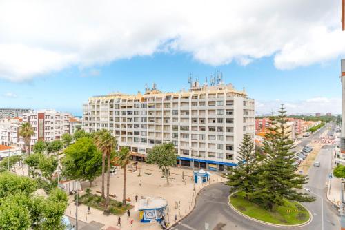 a large building in a city with a street at Lovely 2 Bedroom Apartment in Caparica in Almada
