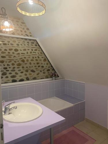 een badkamer met een wastafel en een bad bij La Borde de VINHE in Sauvagnon