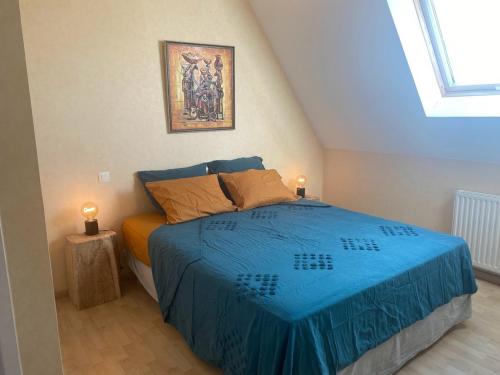 a bedroom with a bed with a blue blanket at La Borde de VINHE in Sauvagnon