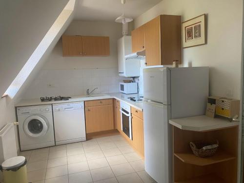 a kitchen with a refrigerator and a washing machine at La Borde de VINHE in Sauvagnon