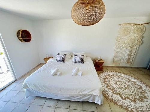 a bedroom with a white bed with white sheets and pillows at Villa Zami in Saint Martin