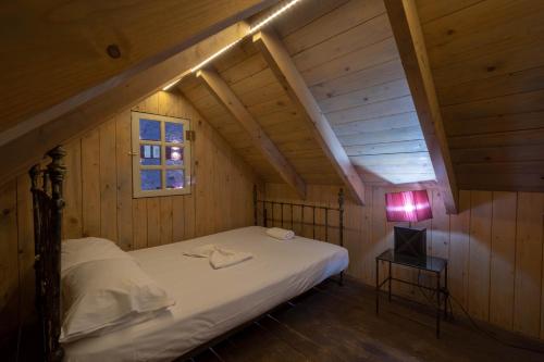 sypialnia z łóżkiem i lampką na poddaszu w obiekcie Agro Art Boutique & Luxury Villa w mieście Vanáton