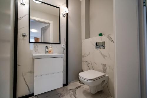 a bathroom with a toilet and a sink and a mirror at Pokoje gościnne Biała Dama in Mławka