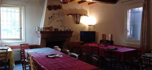 a dining room with two tables and a fireplace at Agriturismo La Riccardina in Budrio