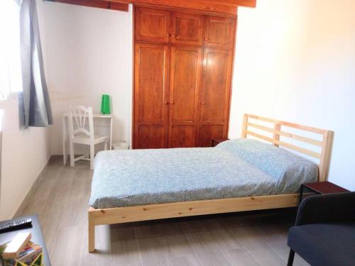 a bedroom with a bed and a wooden cabinet at Estudio Don Antonio en el centro de La Laguna in La Laguna