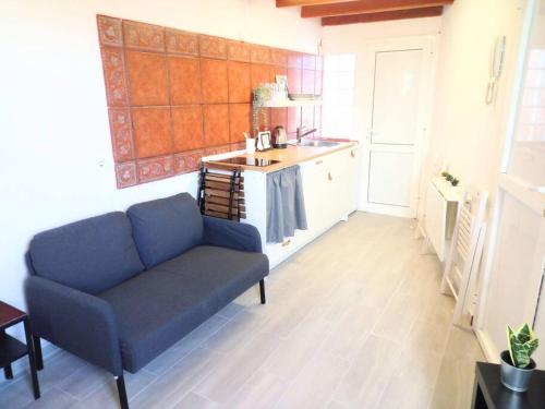 a living room with a blue couch and a kitchen at Estudio Don Antonio en el centro de La Laguna in La Laguna