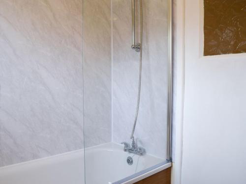 a shower with a glass enclosure in a bathroom at Plum Tree Cottage in Harwich