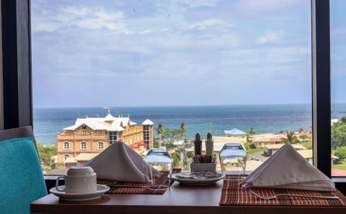 a table with a view of the ocean from a window at Comfort Inn & Suites Tobago in Tobago Island