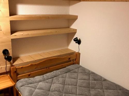 - une petite chambre avec un lit et des étagères en bois dans l'établissement Duplex rénové pour 6/7 pers face aux pistes avec WiFi à Termignon - FR-1-508-222, à Termignon